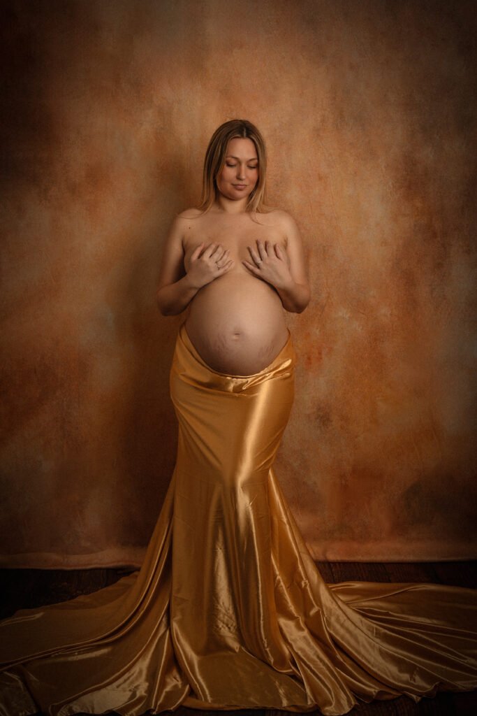 Femme enceinte avec un voilage doré - nu artistique