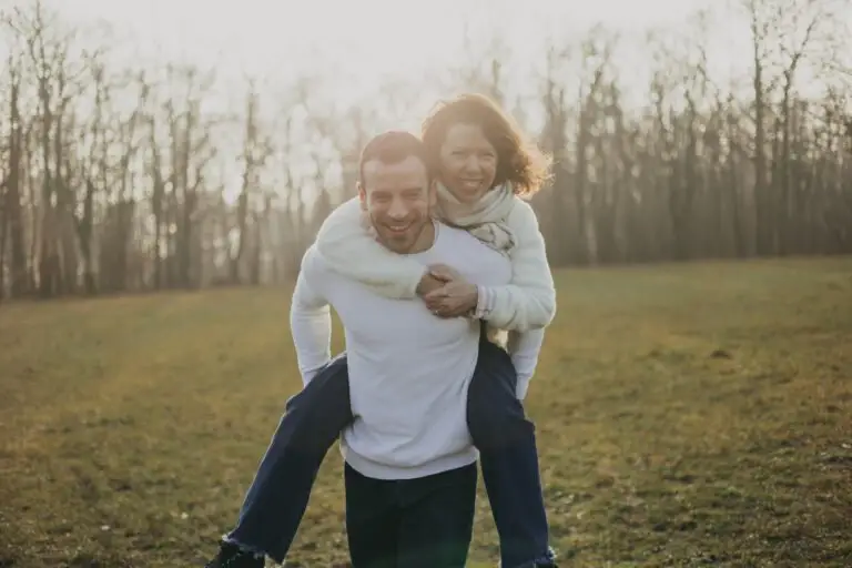 Couple a cheval dans la forêt à contre jour
