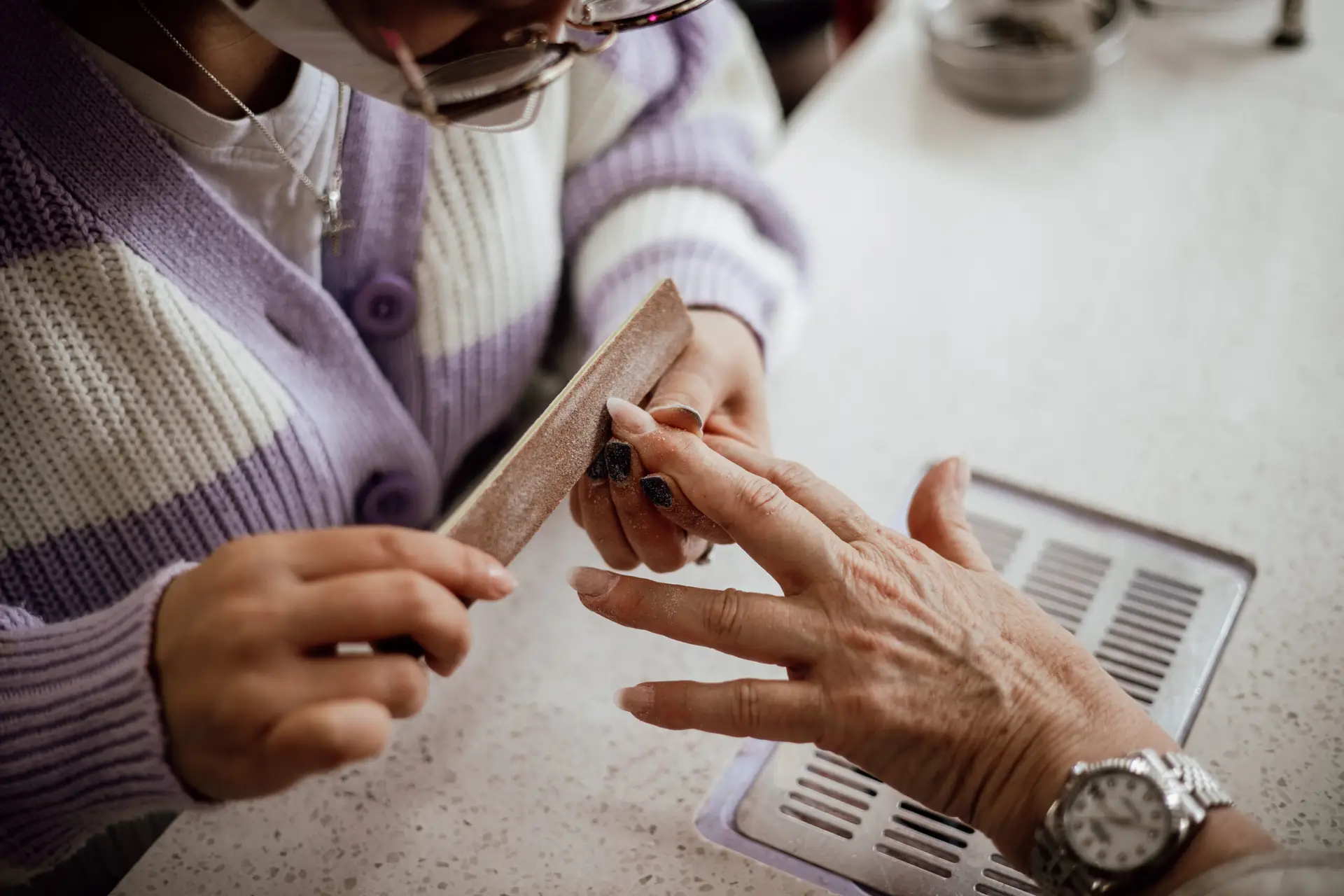 esthéticienne en train de poser des faux ongles